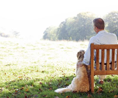 Senior man sitting outdoors with dog